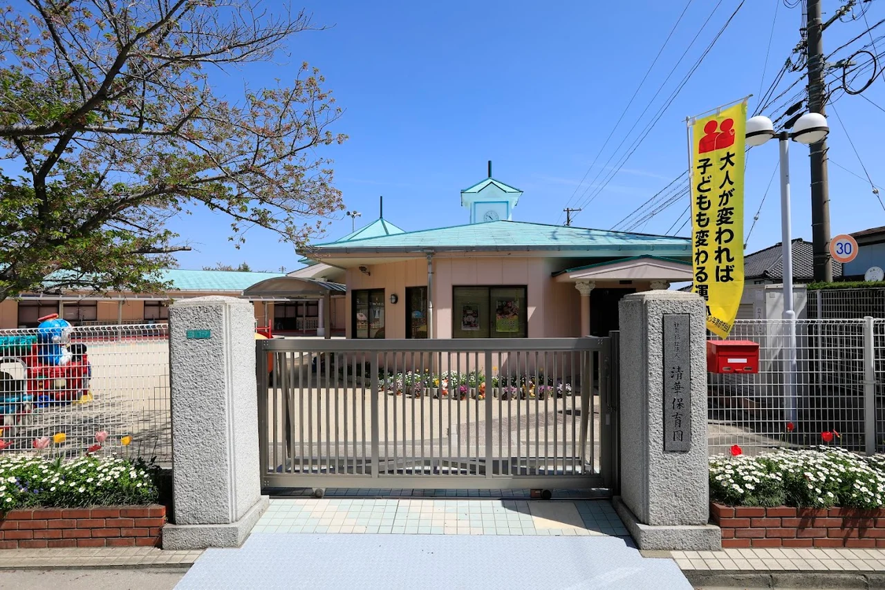 青緑の屋根と花壇のある清華保育園の園舎正面
